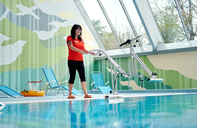 Eine Wellnesstherapeutin lässt ein Wasserfahrrad ins Schwimmbecken