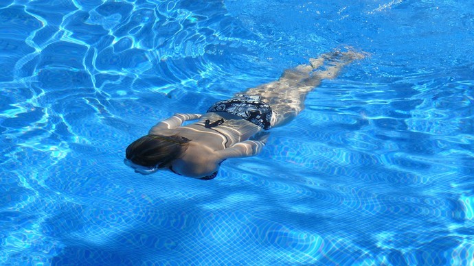 Frau taucht im Schwimmbad
