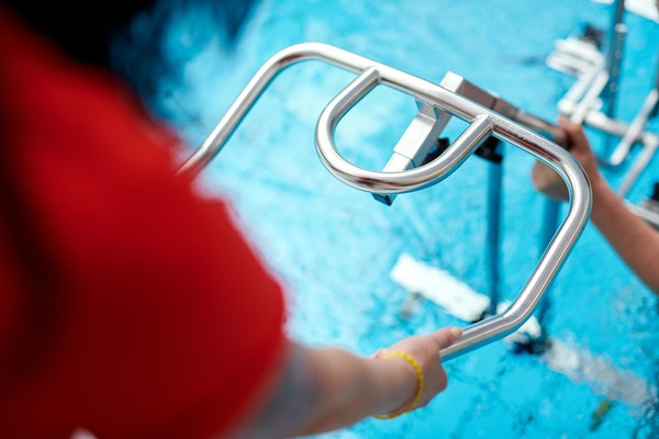 Ein Wasserfahrrad wird ins Schwimmbecken gelassen