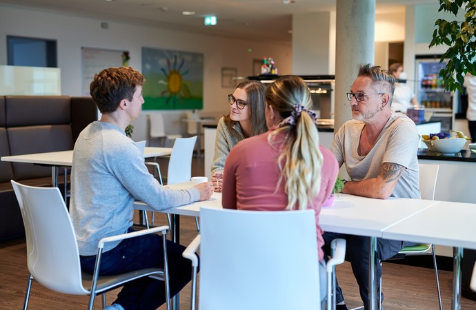 Besuchergruppe an einem Tisch im Café der Klinik.