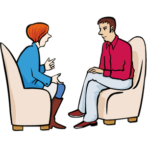 Eine Frau und ein Mann sitzen sich in zwei Sesseln gegenüber, die Frau erzählt dem Mann etwas und er hört aufmerksam zu